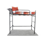 A metal loft with an orange and white comforter, sitting on top of a grey rug
