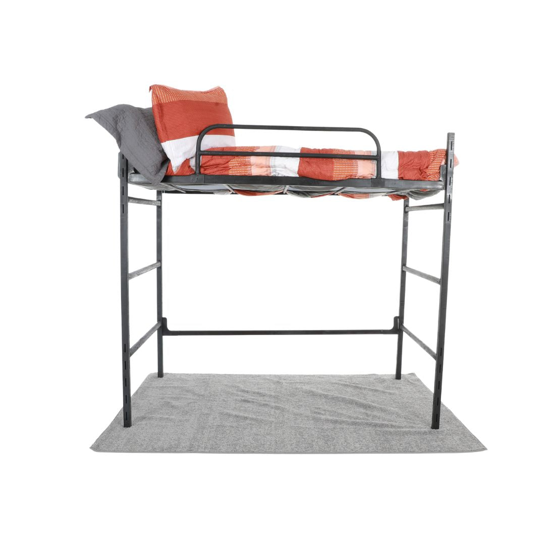 A metal loft with an orange and white comforter, sitting on top of a grey rug
