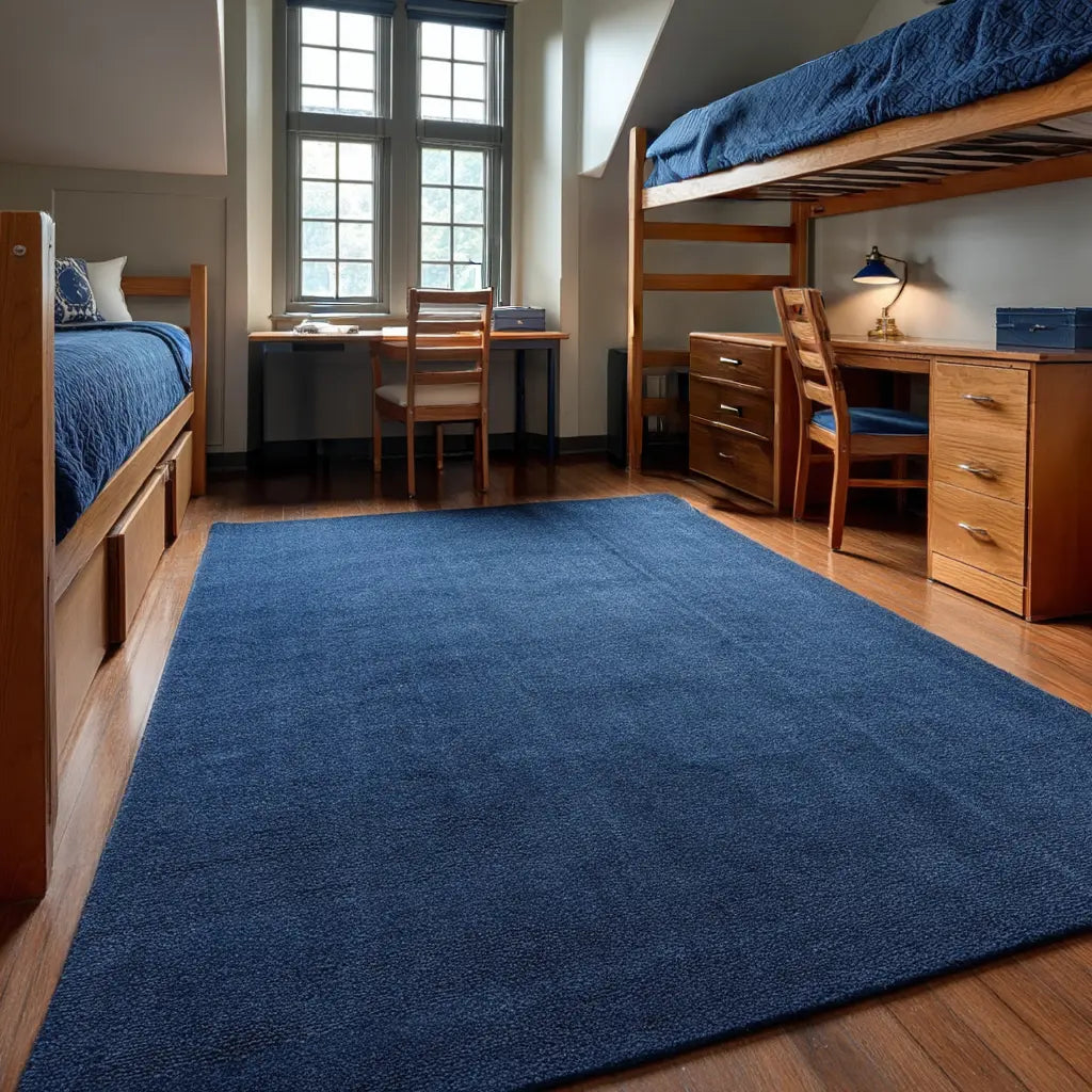 A dorm room setup with lofted beds and desks in a navy color palette